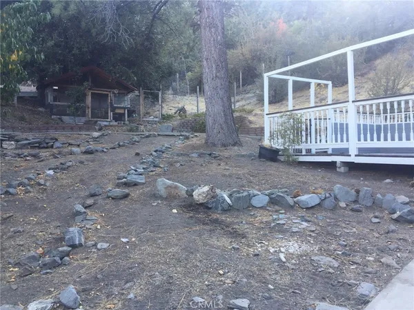 a view of a house with a yard and a wooden deck