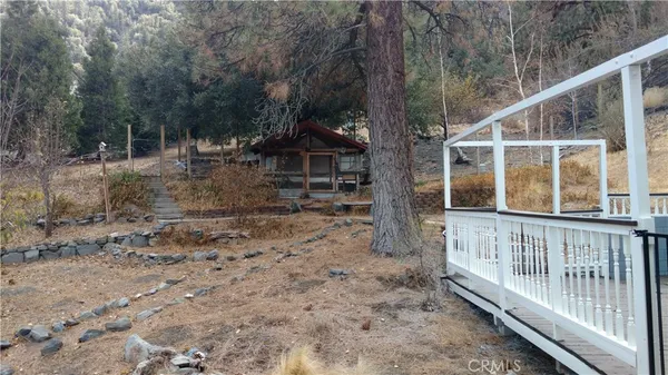 a view of a house with backyard and trees