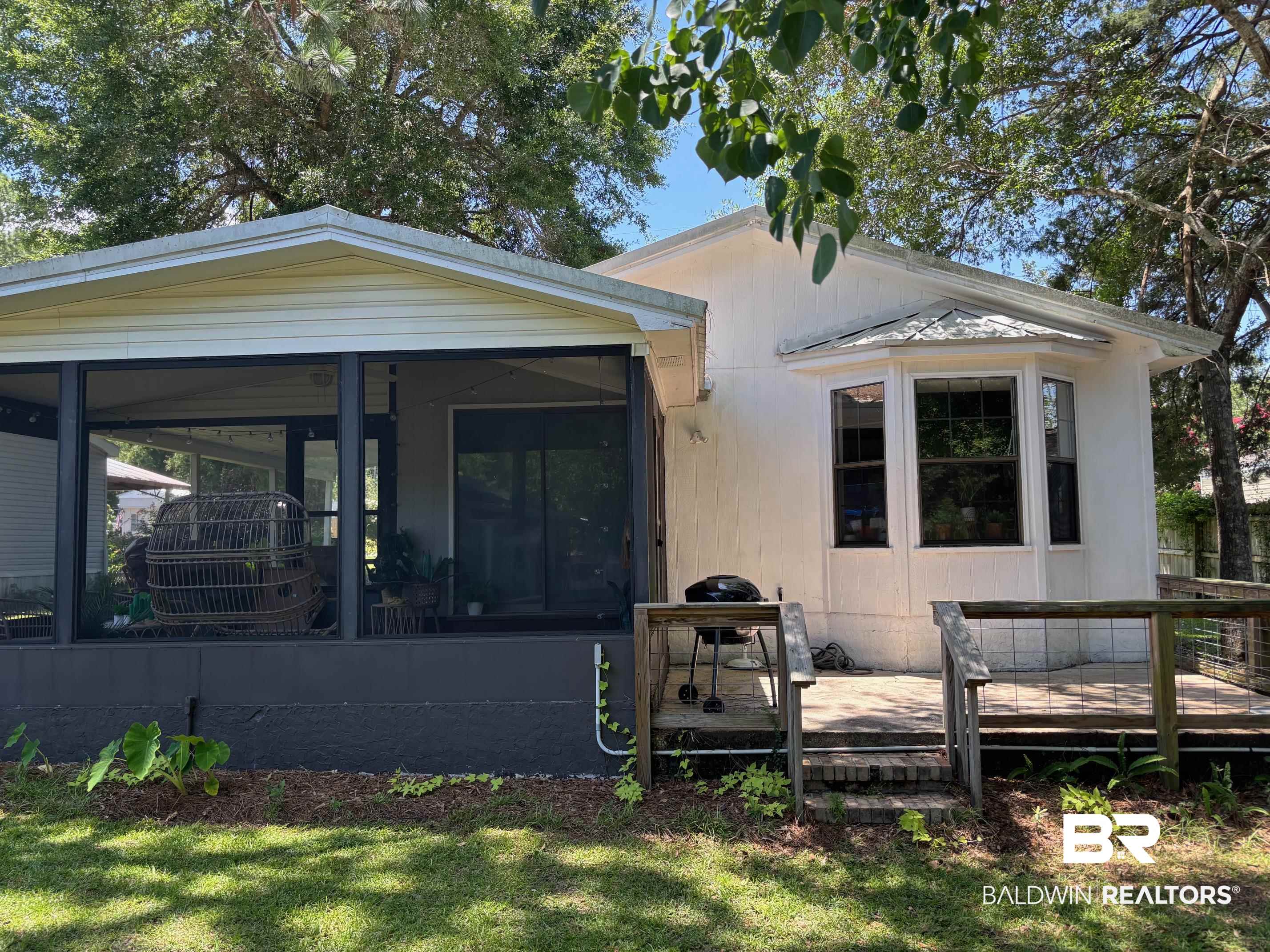 1434 Ridgewood Drive Lillian, AL 36549 - Photo 2 of 45 Rear view of house with a sunroom, a deck, and a yard