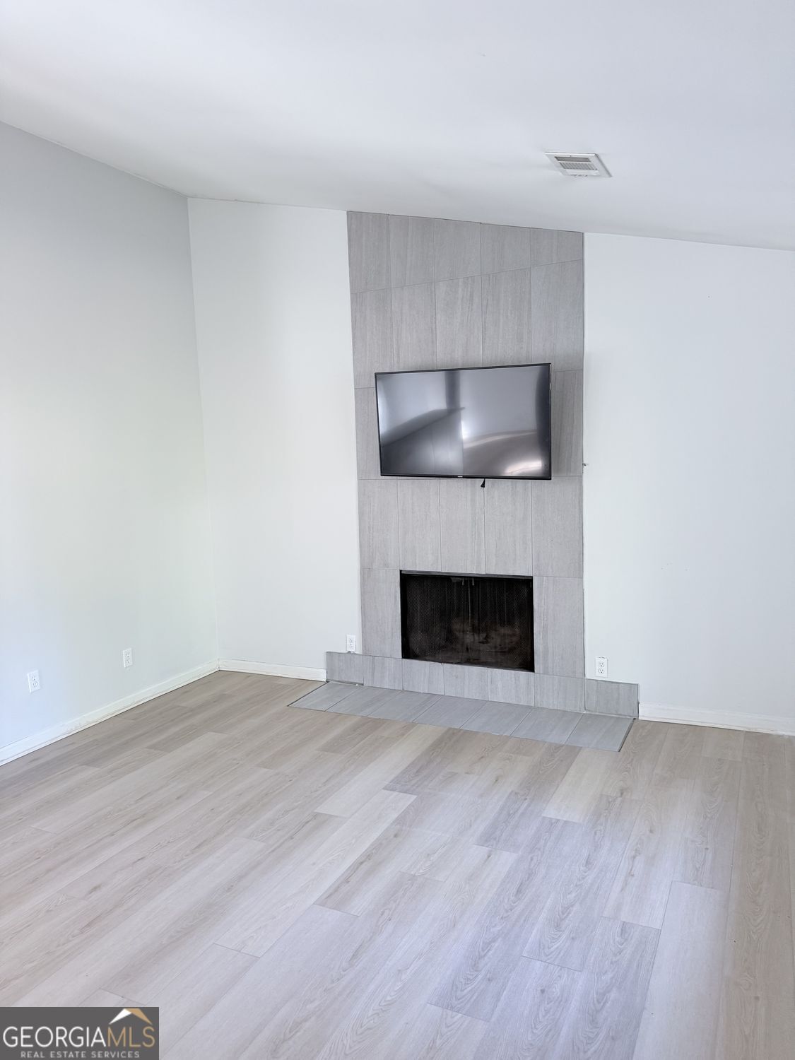 477 Benton Court Southwest Lawrenceville, GA 30044 - Photo 2 of 17 a view of an empty room with wooden floor and a fireplace