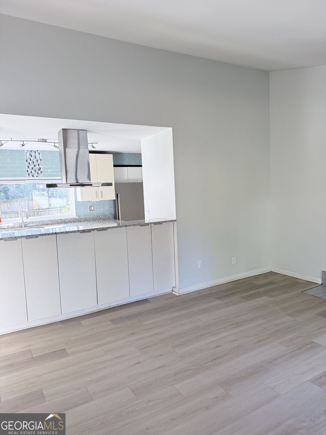 477 Benton Court Southwest Lawrenceville, GA 30044 - Photo 4 of 17 a kitchen with granite countertop white cabinets and wooden floor