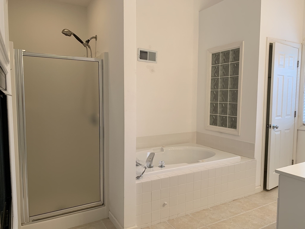 73 Half Crown Circle, Unit 73 Ashland, MA 01721 - Photo 14 of 18 a white bath tub sitting next to a shower