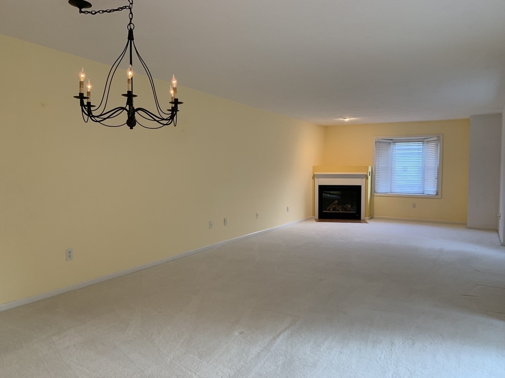 73 Half Crown Circle, Unit 73 Ashland, MA 01721 - Photo 4 of 18 a view of empty room with a fireplace