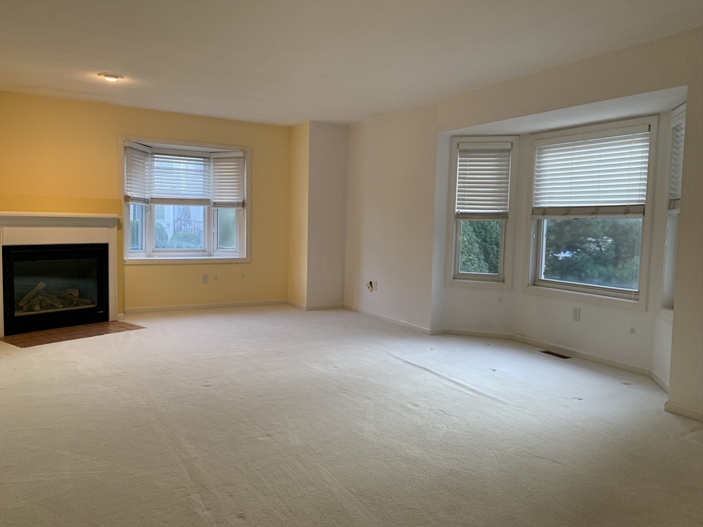 73 Half Crown Circle, Unit 73 Ashland, MA 01721 - Photo 5 of 18 a view of empty room with a fireplace