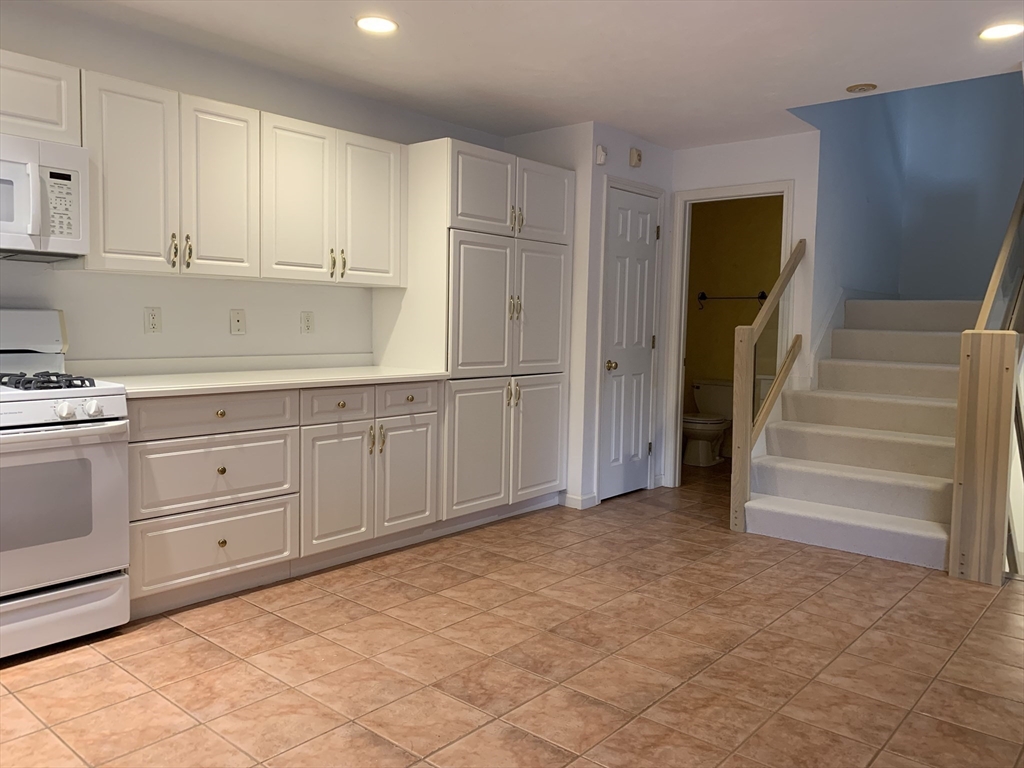 73 Half Crown Circle, Unit 73 Ashland, MA 01721 - Photo 7 of 18 a kitchen with white cabinets and white appliances