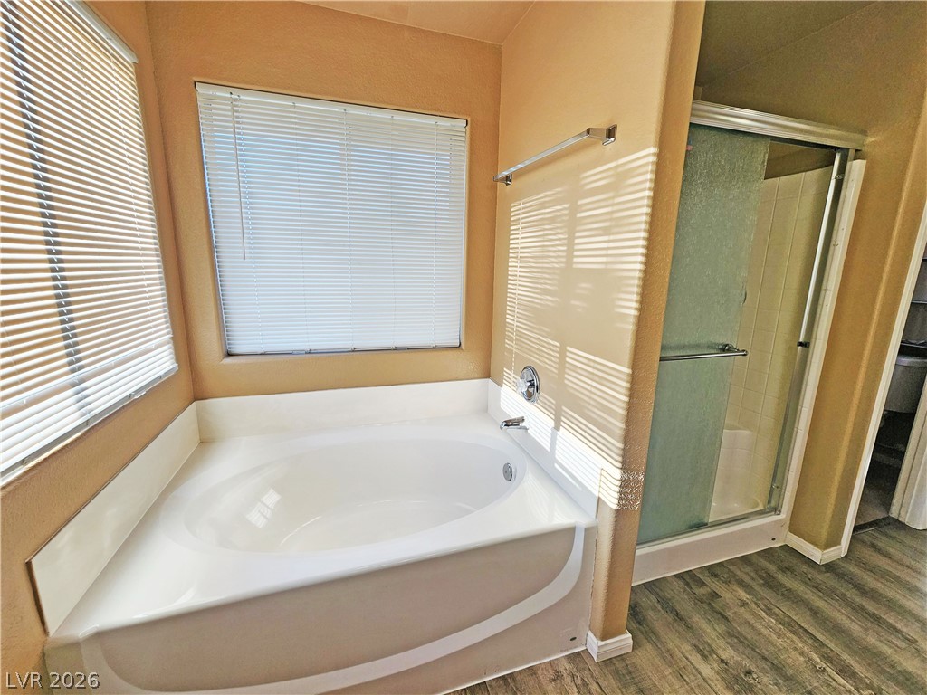 3680 Ravine Avenue Pahrump, NV 89048 - Photo 16 of 28 Full bathroom with a garden tub, wood finished floors, and a stall shower