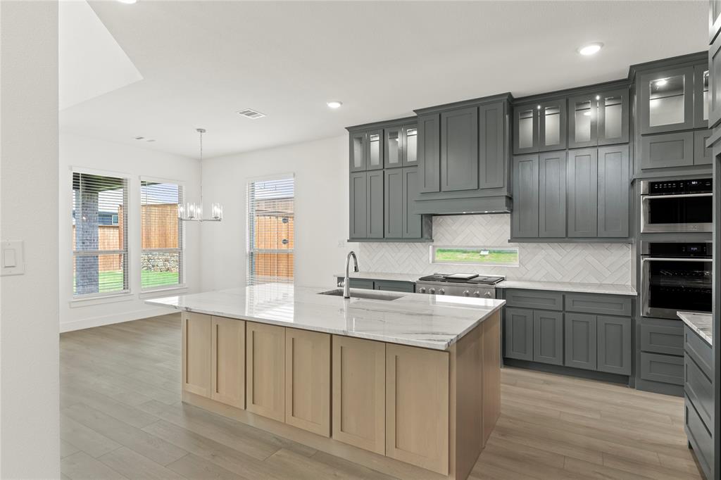 971 Georgetown Place Prosper, TX 75078 - Photo 17 of 34 a kitchen with stainless steel appliances granite countertop a sink stove and refrigerator