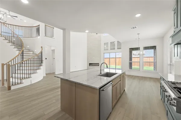 a kitchen that has a lot of cabinets and wooden floor