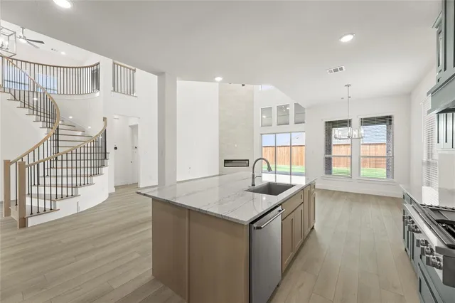 a kitchen that has a lot of cabinets and wooden floor