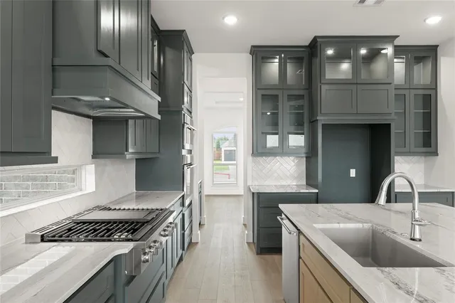a kitchen with granite countertop a sink stove and cabinets
