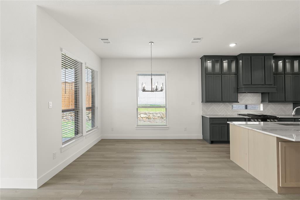 971 Georgetown Place Prosper, TX 75078 - Photo 20 of 34 a kitchen with stainless steel appliances granite countertop a stove a sink and a refrigerator