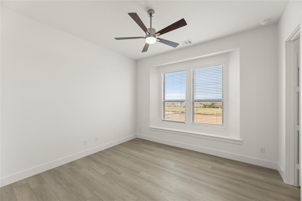 971 Georgetown Place Prosper, TX 75078 - Photo 7 of 34 an empty room with wooden floor fan and windows