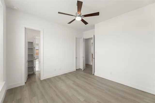 a view of room with hardwood floor and a ceiling fan