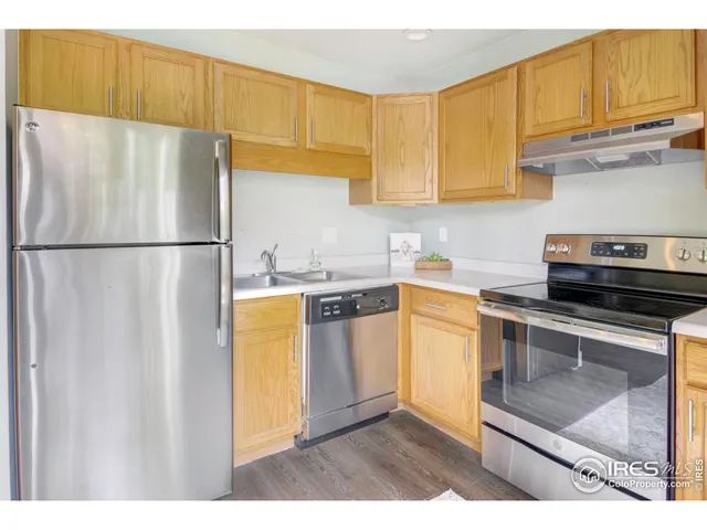 a kitchen with a refrigerator sink and cabinets