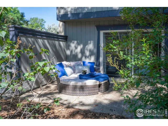 a view of a chair and table in the backyard with plants