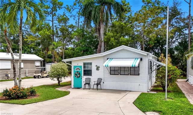 a front view of a house with a garden and trees
