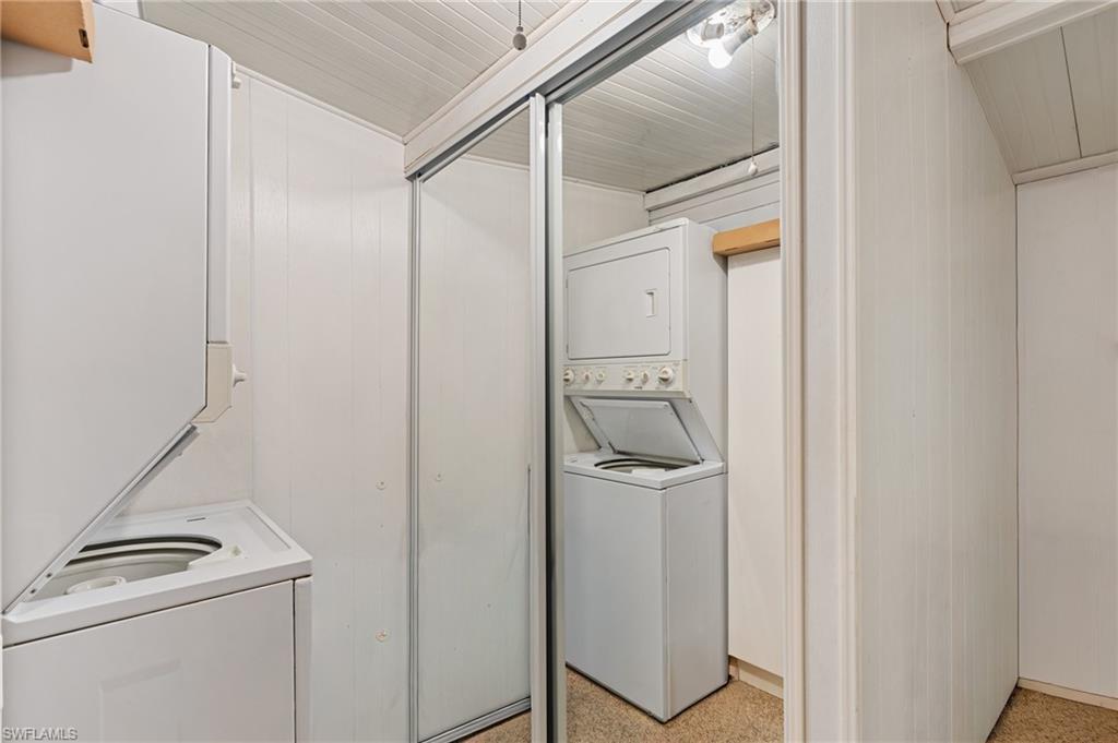 37 Bass Lane Naples, FL 34114 - Photo 13 of 29 Laundry area with dark aggregate flooring and estacked washer and dryer