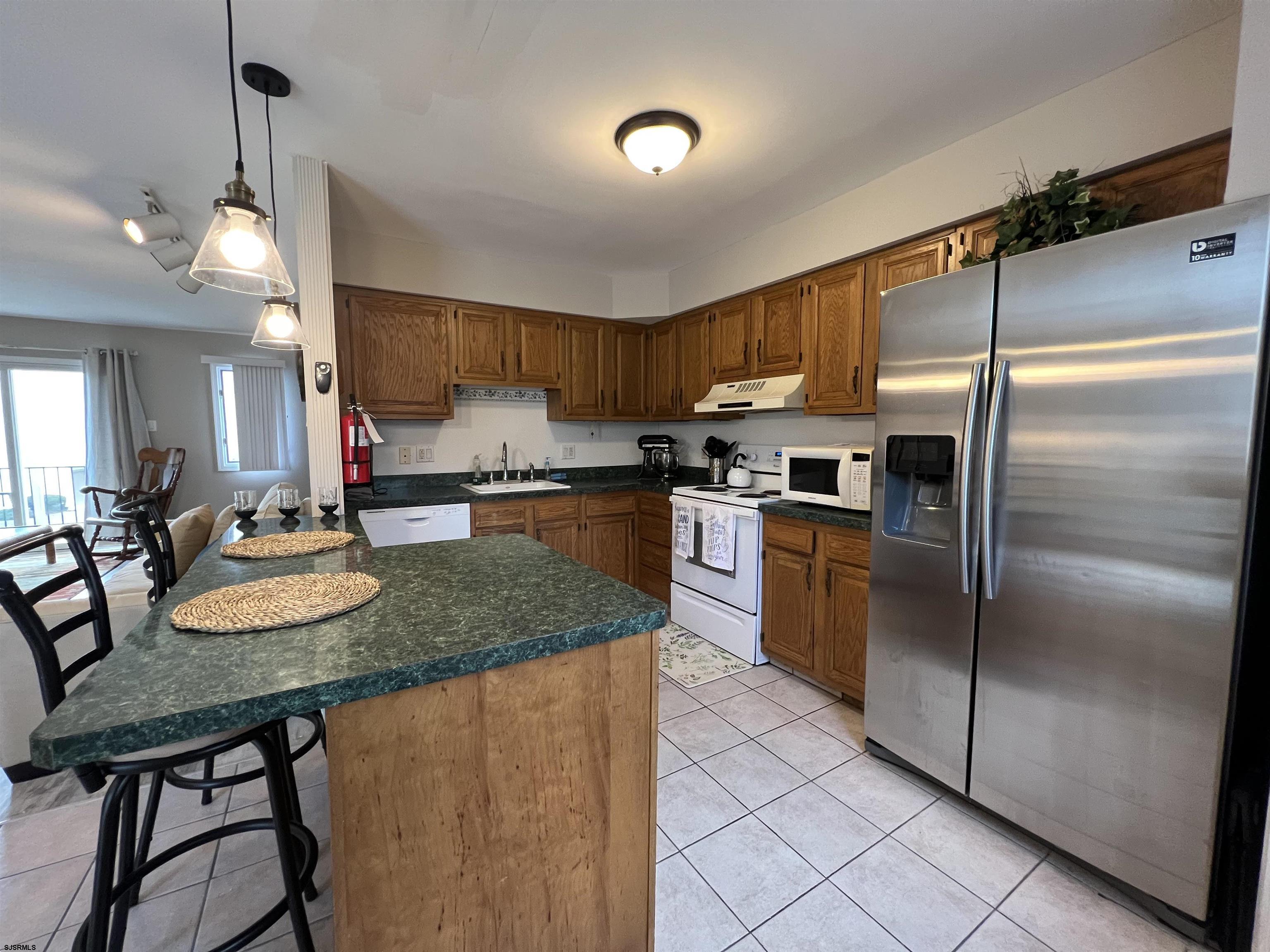 11 Surfside Road, Unit 11 Brigantine, NJ 08203 - Photo 20 of 21 a kitchen with stainless steel appliances granite countertop a sink a stove a refrigerator and island