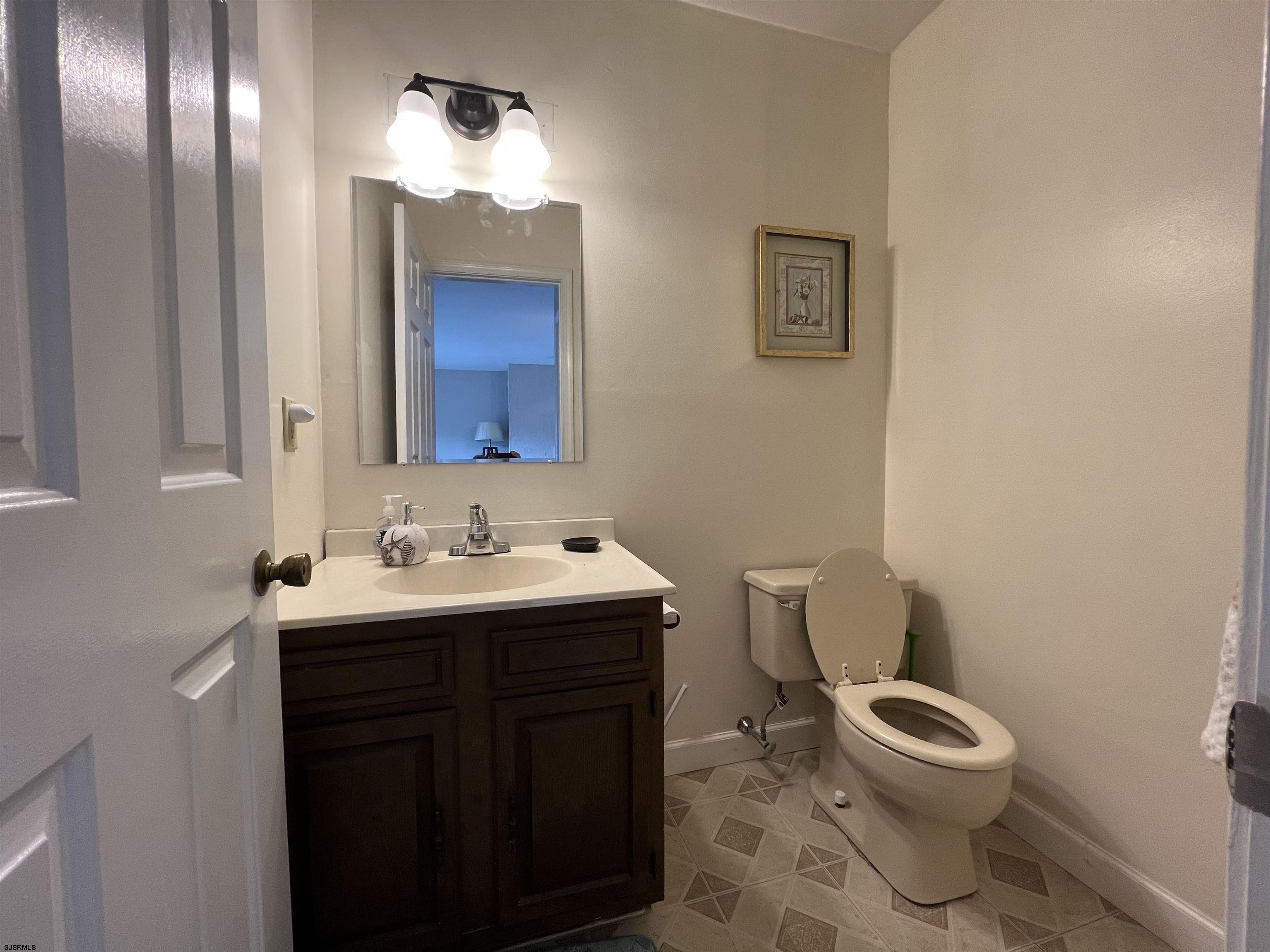 11 Surfside Road, Unit 11 Brigantine, NJ 08203 - Photo 5 of 21 a bathroom with a toilet a sink and mirror