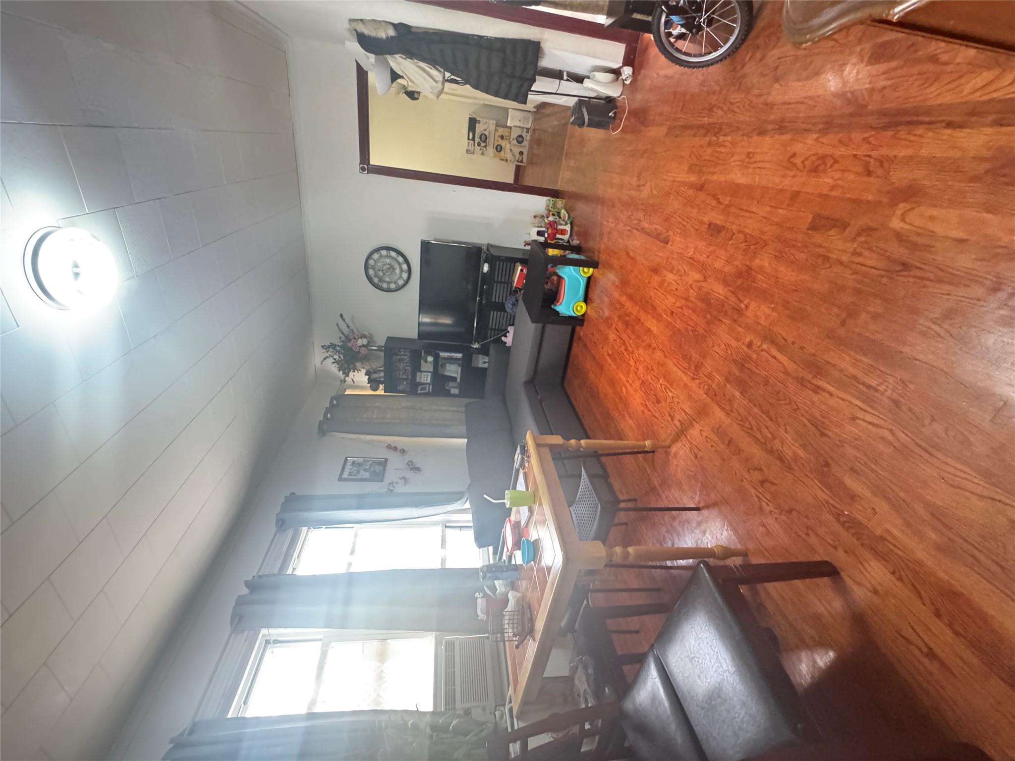 88-16 85th Street Queens, NY 11421 - Photo 11 of 11 Living room featuring wood finished floors and a desk
