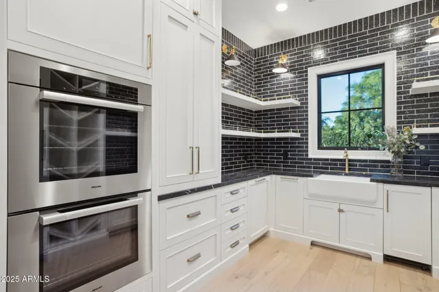 a kitchen with granite countertop white cabinets and window