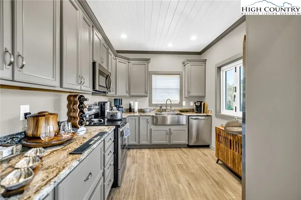 a kitchen with stainless steel appliances granite countertop a sink stove microwave and refrigerator