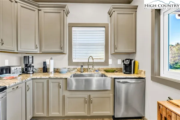 a kitchen with granite countertop a sink a stove and cabinets