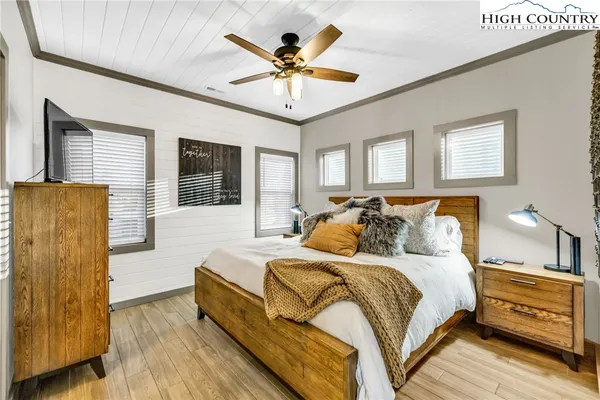 a bedroom with a bed and wooden floor