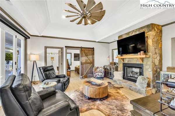 a living room with furniture a fireplace and a flat screen tv