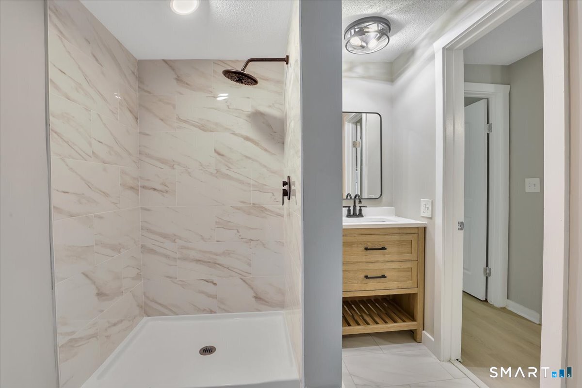 16 Strong Street Burlington, CT 06013 - Photo 18 of 36 a bathroom with a bathtub a shower a sink and a mirror