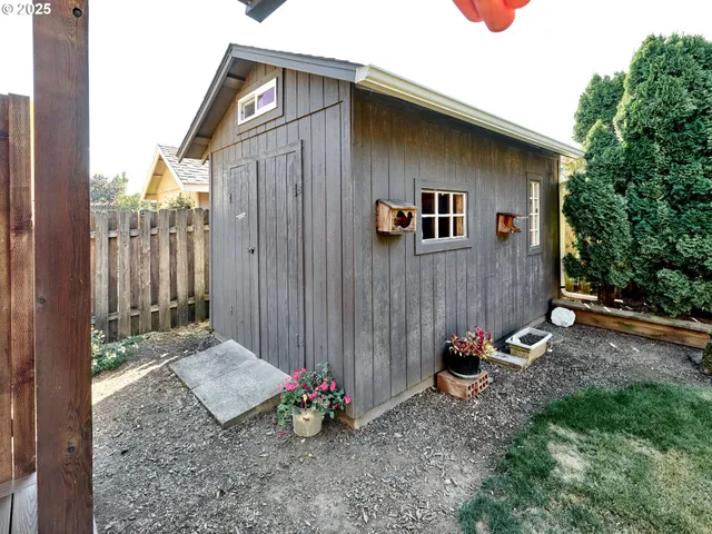 a backyard of a house with wooden floor potted plants and wooden fence
