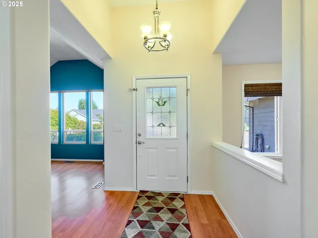 a view of a hallway with wooden floor and windows