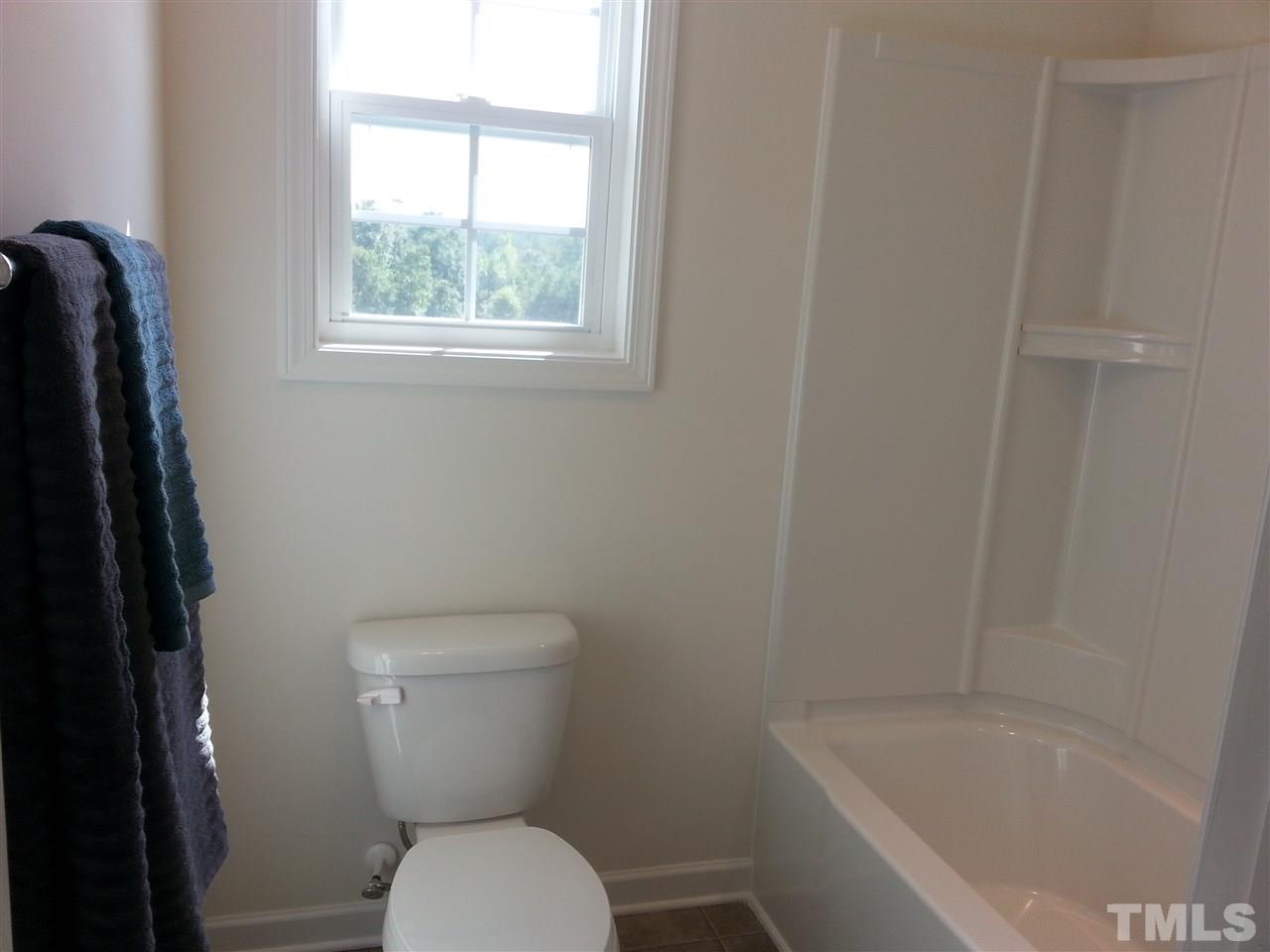 7516 Channery Way Raleigh, NC 27616 - Photo 16 of 25 a white toilet sitting next to a bath tub