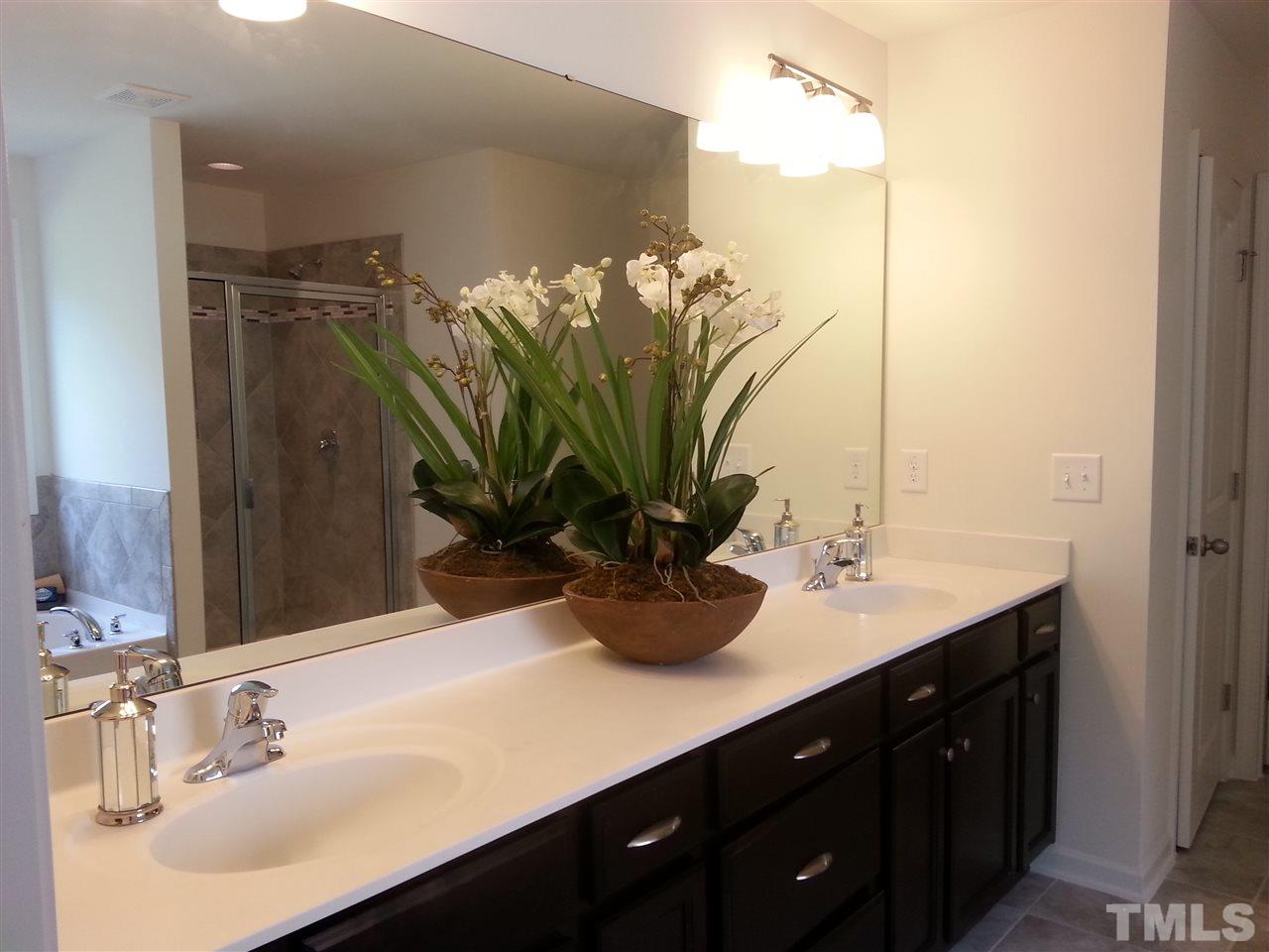 7516 Channery Way Raleigh, NC 27616 - Photo 21 of 25 a bathroom with a double vanity sink and a mirror
