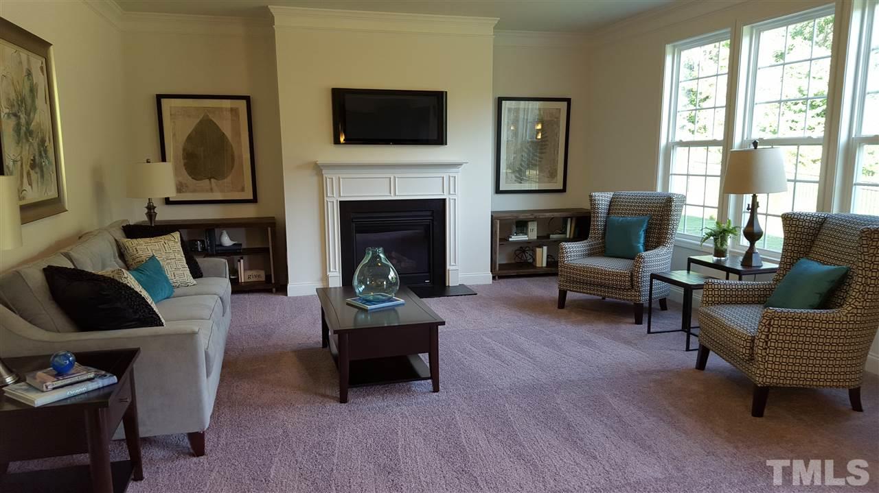 7516 Channery Way Raleigh, NC 27616 - Photo 5 of 25 a living room with furniture a flat screen tv and a fireplace