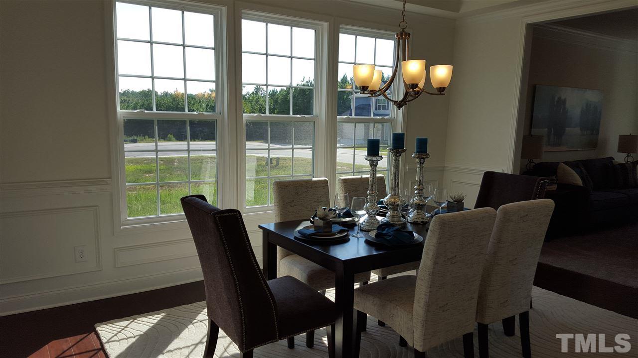 7516 Channery Way Raleigh, NC 27616 - Photo 6 of 25 a dining room with furniture wooden floor and a potted plant