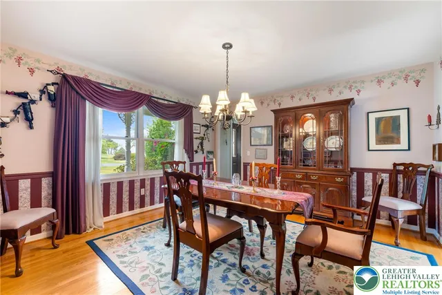 a view of a hallway to a livingroom with wooden floor and stairs