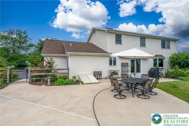 a patio with table and chairs and potted plants