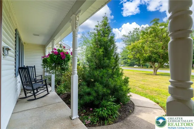 a porch with a table and chairs and potted plants