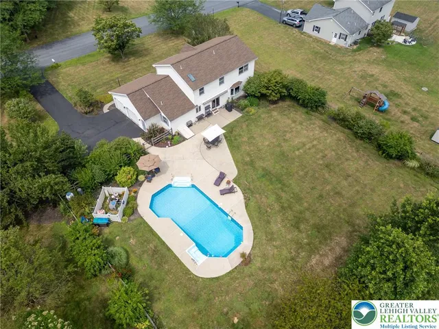 an aerial view of a house with a swimming pool and outdoor space