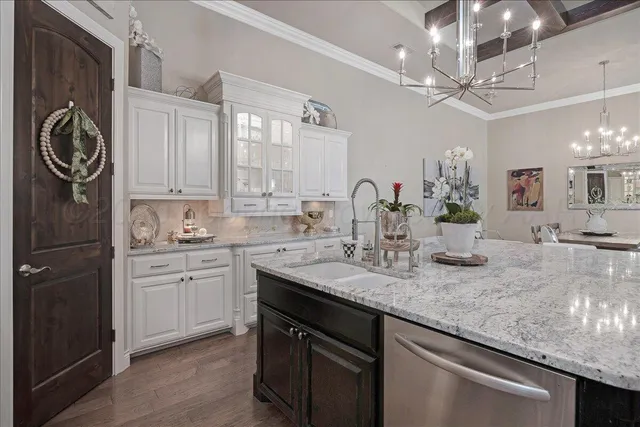 a kitchen with kitchen island granite countertop a sink a stove and cabinets