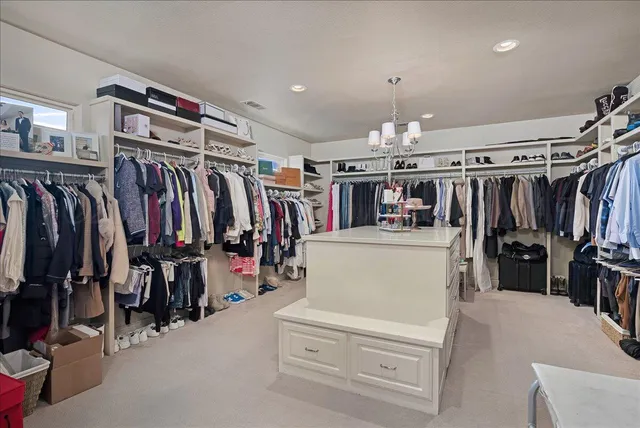 a view of walk in closet with clothes and shoes
