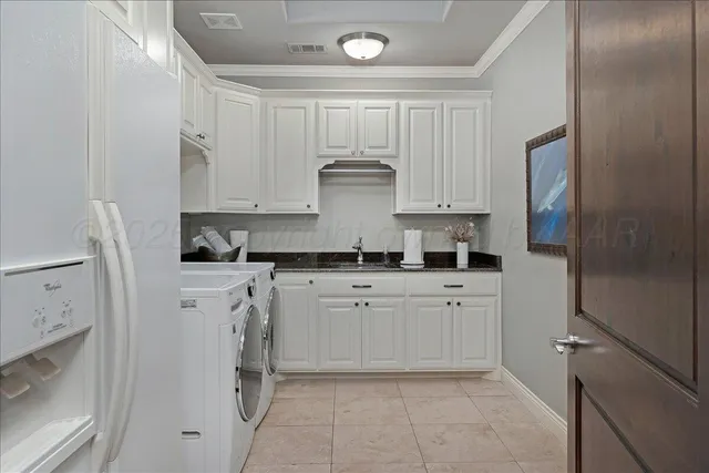 a kitchen with stainless steel appliances granite countertop a refrigerator and white cabinets