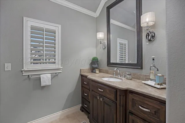 a bathroom with a granite countertop sink a large mirror a and a window