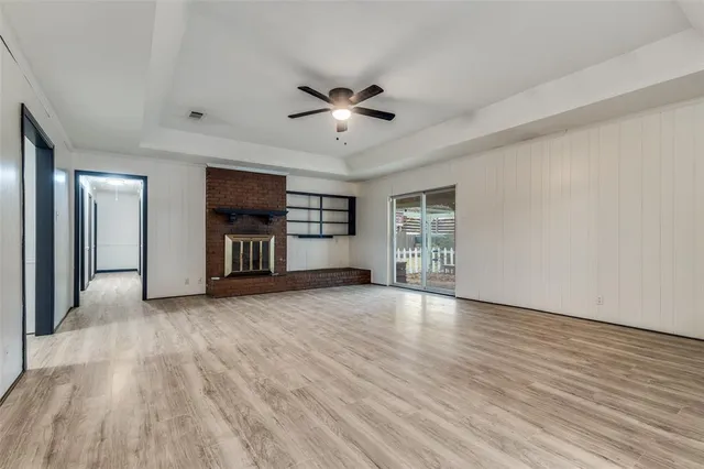 a view of an empty room with a window and fireplace