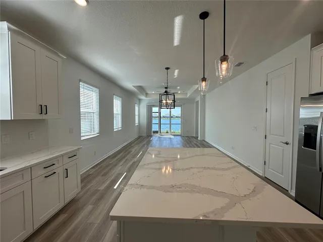 a large kitchen with kitchen island a stove a sink dishwasher and a oven with white cabinets