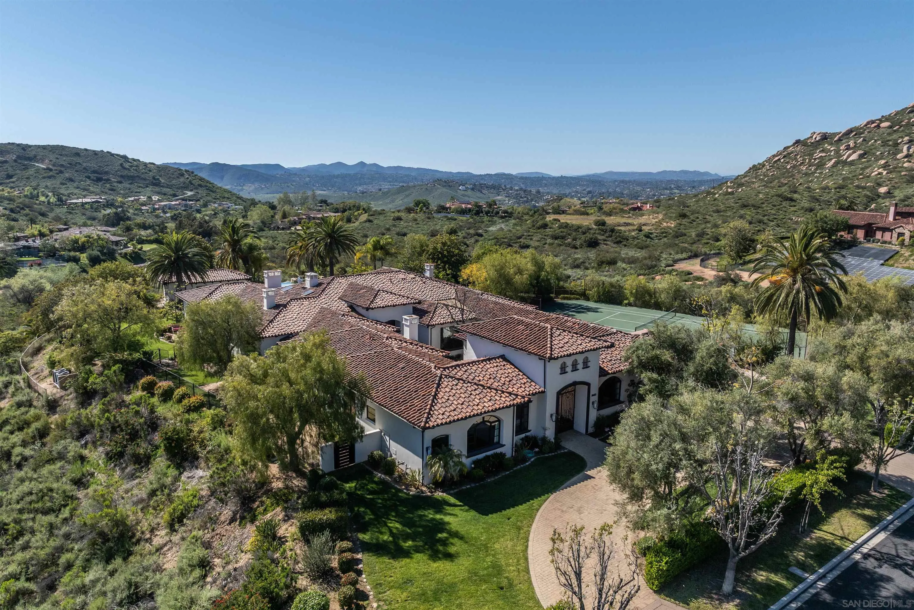 an aerial view of residential houses with outdoor space and trees