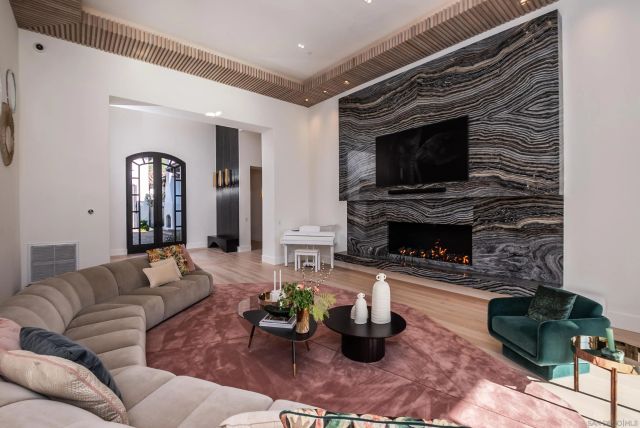 a living room with furniture a flat screen tv and a fireplace