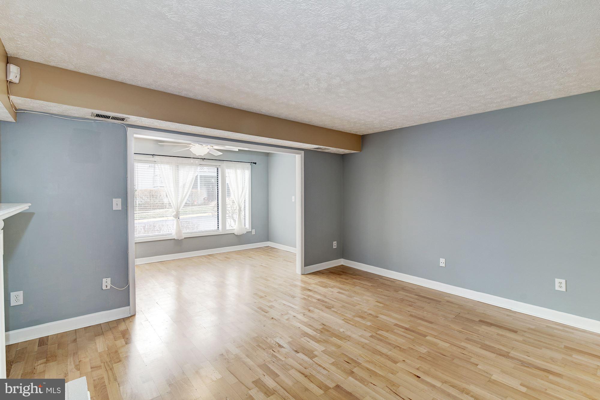 2224 Hunter's Run Drive, Unit 2224 Reston, VA 20191 - Photo 1 of 21 a view of an empty room with wooden floor and a window