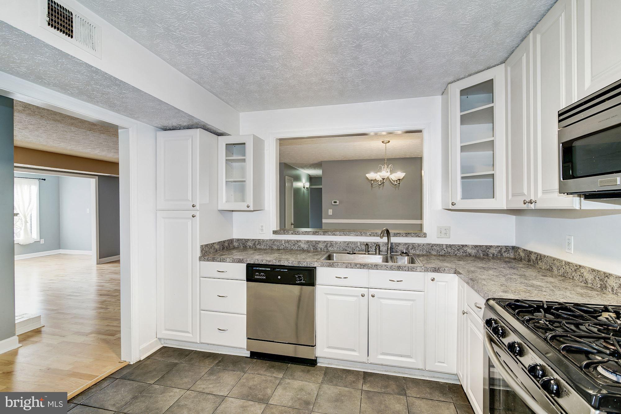 2224 Hunter's Run Drive, Unit 2224 Reston, VA 20191 - Photo 12 of 21 a kitchen with granite countertop a sink stove and cabinets